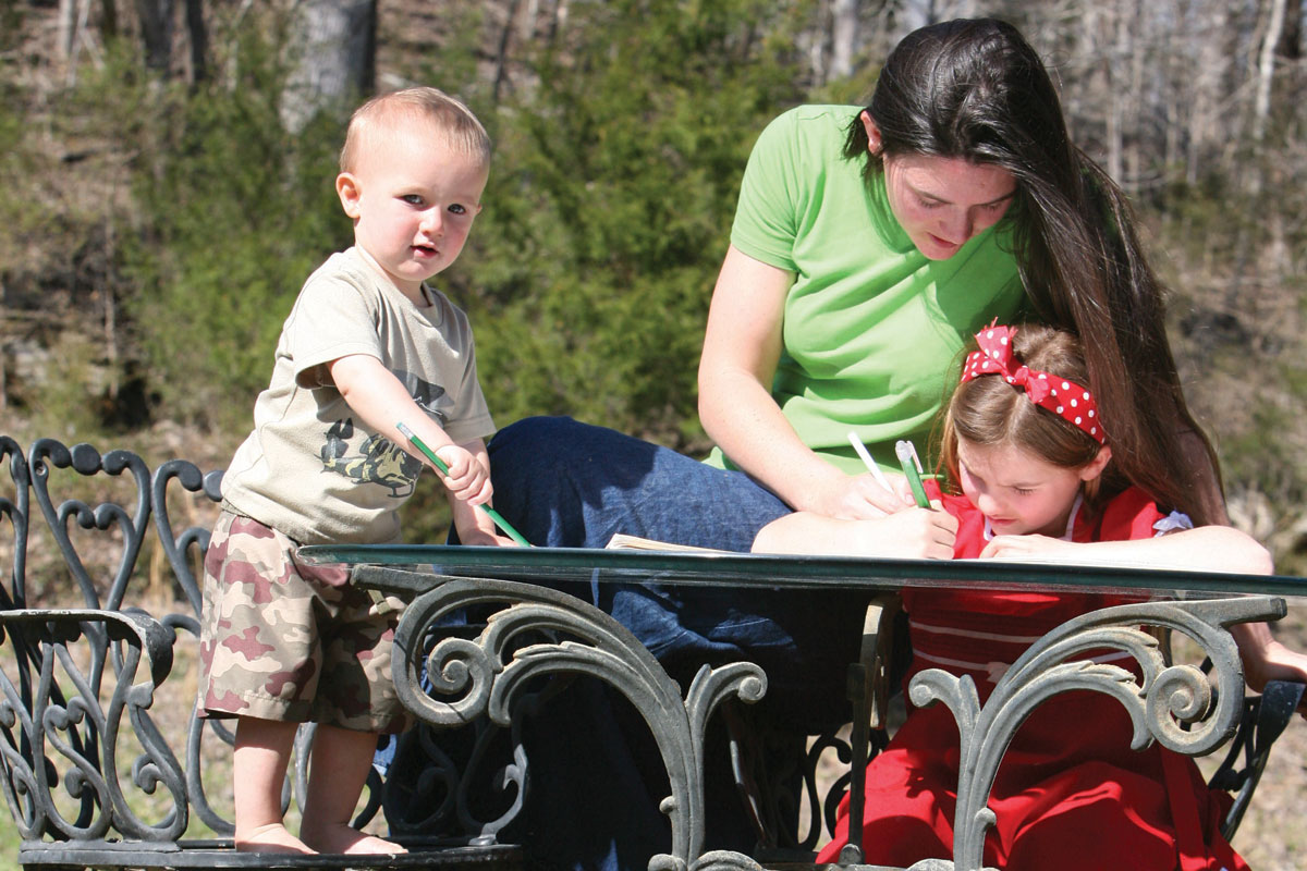A mom homeschooling her little girl and toddler