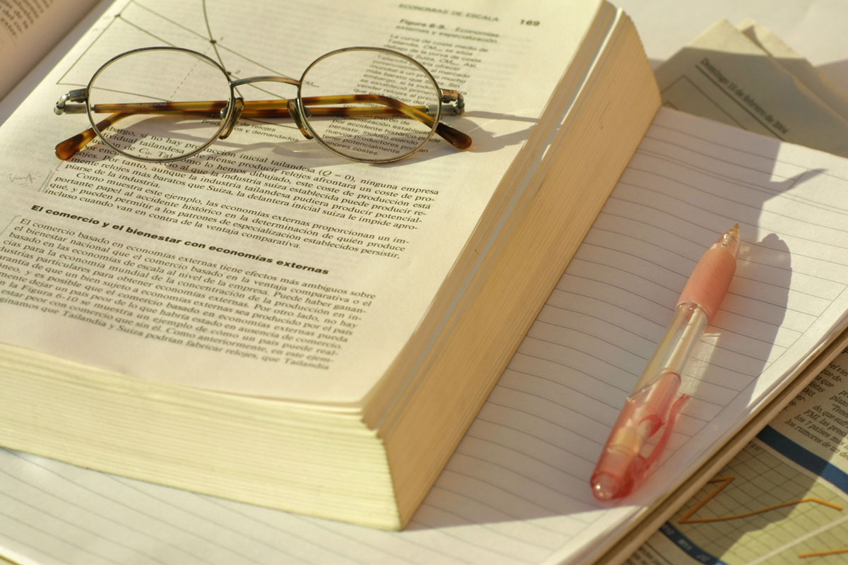 Glasses, books, notebook, and pen.