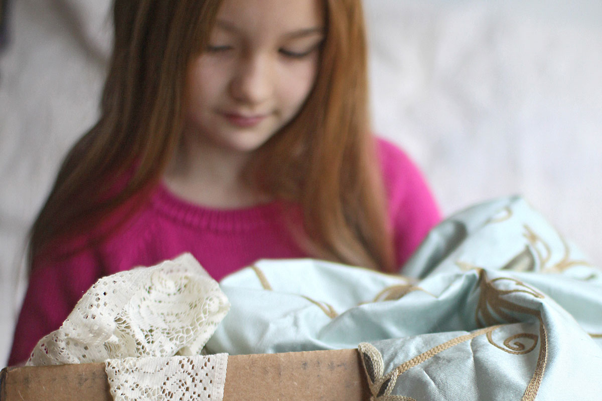 Young girl with a box of fabric