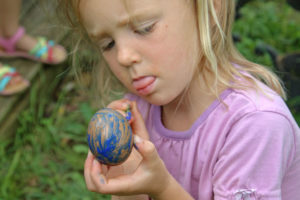 Young girl painting an egg